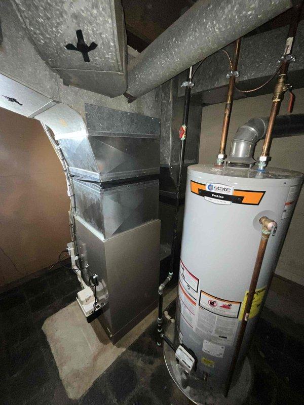 Conducted site evaluation for air conditioning system replacement in basement mechanical room where previous unit had been removed. Assessed existing ductwork configuration, electrical infrastructure, and available space constraints around furnace and water heater to determine proper equipment sizing and installation requirements for new cooling system.