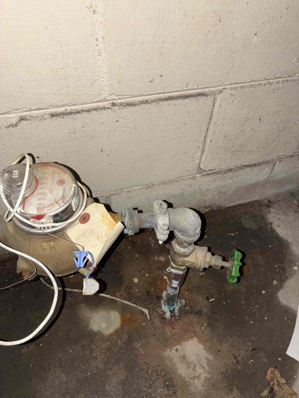 Replaced a 1-inch threaded gate valve at the water service line to facilitate water meter servicing by the municipal water department. The existing valve was removed and a new gate valve was installed using threaded connections on the galvanized piping assembly located near the water meter at floor level.