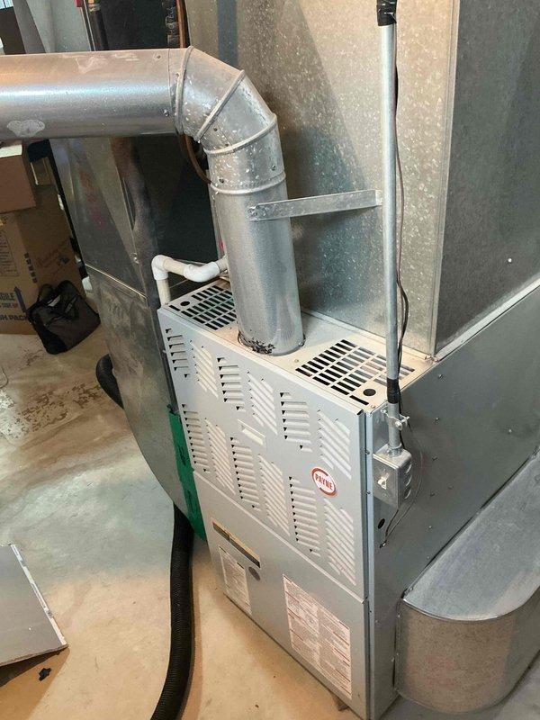 Conducted comprehensive full system HVAC assessment for residential property with 16-year-old air conditioning system requiring replacement within the current season. Evaluated existing Payne brand furnace installation in basement utility area with connected metallic ductwork and assessed overall system configuration including plenum assembly, duct transitions, and insulated refrigerant lines. Documented equipment condition and existing infrastructure through detailed photography to provide accurate replacement system specifications and installation requirements.