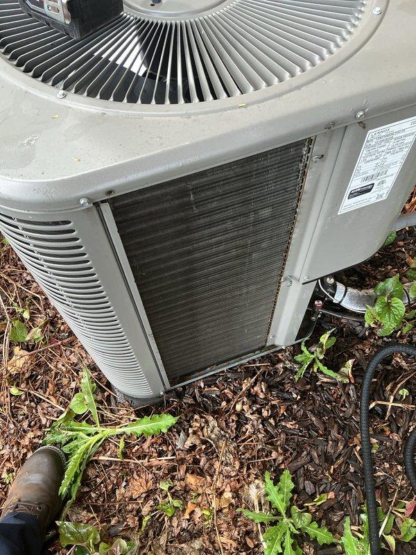 Completed annual cooling maintenance on residential air conditioning system. Performed system diagnostics using digital manifold gauge set, inspected condensing unit operation, and evaluated overall equipment condition. Unit exterior panels showed weathering and dirt accumulation; heat exchanger coils were accessible for inspection. Noted vegetation growth and debris around unit base that may restrict airflow if not maintained. System operational at time of service.