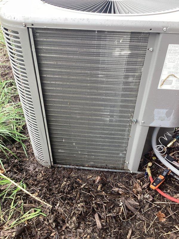 Performed annual cooling maintenance on outdoor condensing unit. Inspected condenser coils and found significant accumulation of dust, dirt, and debris throughout the fin assembly, restricting airflow and reducing heat transfer efficiency. Removed access panels and cleaned condenser coils to restore proper airflow. Verified unit operational status and documented pre-maintenance condition with photographs showing heavy contamination on heat exchanger surfaces.