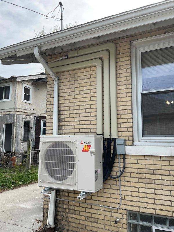 Completed full installation of Mitsubishi Electric mini-split system on residential property. Mounted outdoor condenser unit on exterior brick wall using secure metal bracket, ran refrigerant lines and electrical conduit along exterior wall with proper securing clips, and installed new dedicated electrical circuit per permit requirements. All mechanical and electrical permits obtained and work completed to code specifications.