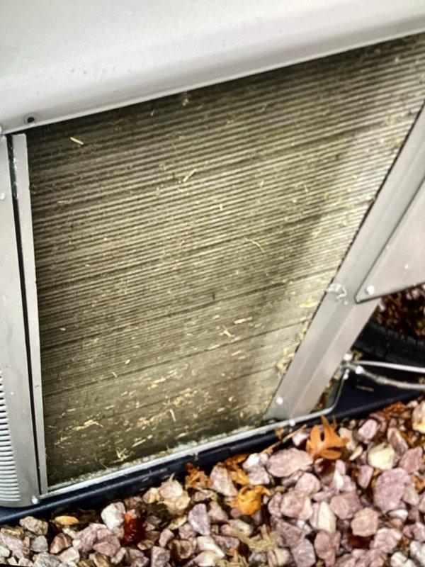 Completed spring maintenance and AC tune-up on a three-year-old central air conditioning system. Inspected outdoor condenser unit and found significant dust and debris accumulation on coil fins, along with scattered insulation material at base requiring cleanup. Performed thorough cleaning of condenser coils to restore proper airflow and heat transfer efficiency, removed debris from unit perimeter, and verified all components are functioning within normal operating parameters.