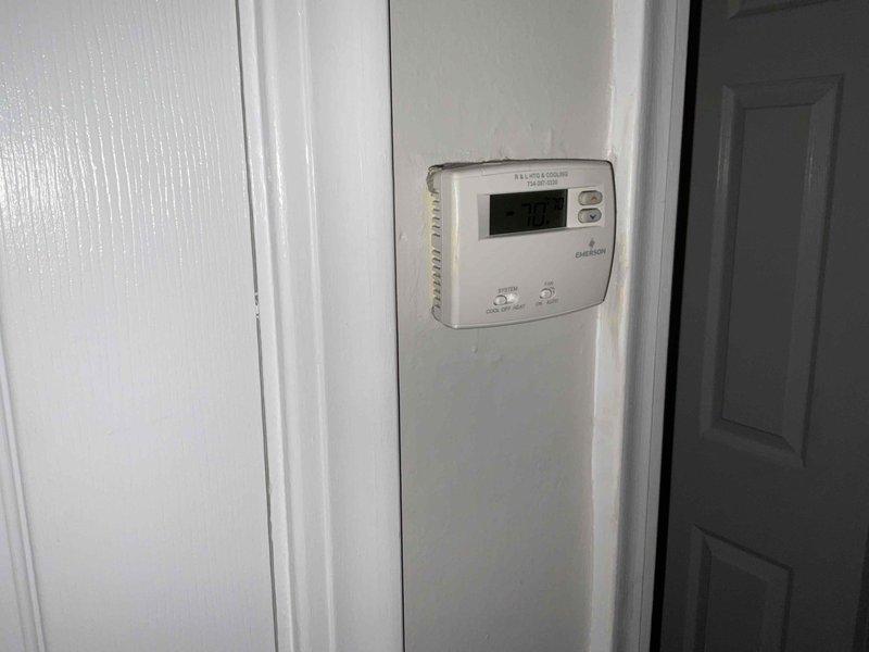 Conducted free estimate for air conditioning system replacement. Existing unit is 26 years old and nearing end of service life. Documented current system configuration including White-Rodgers Emerson thermostat and outdoor condensing unit positioned on concrete pad in side yard with electrical service connection via green conduit and disconnect box. Provided replacement options and recommendations for new AC system installation.