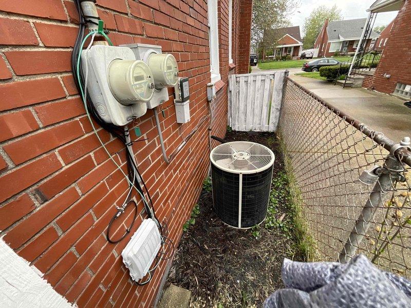 Conducted free estimate for air conditioning system replacement. Existing unit is 26 years old and nearing end of service life. Documented current system configuration including White-Rodgers Emerson thermostat and outdoor condensing unit positioned on concrete pad in side yard with electrical service connection via green conduit and disconnect box. Provided replacement options and recommendations for new AC system installation.