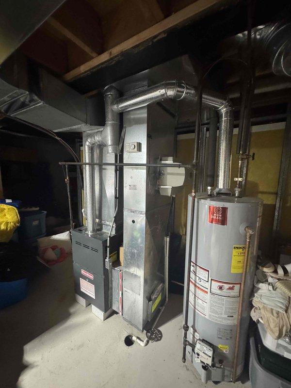 Conducted on-site evaluation of 15-year-old residential air conditioning system experiencing complete refrigerant loss due to obsolete components. Assessed existing 4-ton AC unit, associated refrigerant lines, and evaporator coil located in unfinished basement area with accessible installation points. Documented current equipment condition, verified system specifications, and photographed furnace location and ductwork configuration to provide comprehensive replacement estimate for complete AC system upgrade.