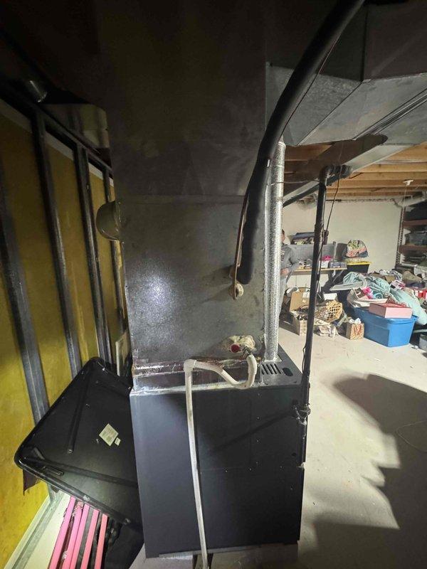 Conducted on-site evaluation of 15-year-old residential air conditioning system experiencing complete refrigerant loss due to obsolete components. Assessed existing 4-ton AC unit, associated refrigerant lines, and evaporator coil located in unfinished basement area with accessible installation points. Documented current equipment condition, verified system specifications, and photographed furnace location and ductwork configuration to provide comprehensive replacement estimate for complete AC system upgrade.