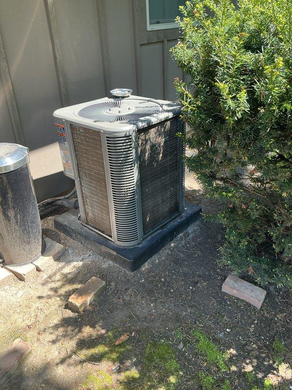 Completed annual cooling maintenance on outdoor condensing unit. Performed comprehensive system inspection including visual assessment of cabinet condition, coil cleanliness, and overall equipment operation. Unit showed significant exterior weathering with heavy black streaking and staining on metal panels, indicating accumulated dirt, oxidation, and biological growth. Documented equipment condition with detailed photographs for service records. Heat exchanger coils exhibited dust and debris buildup typical of outdoor HVAC equipment. Verified fan grille assembly and mounting hardware secure. System operational at time of service completion.