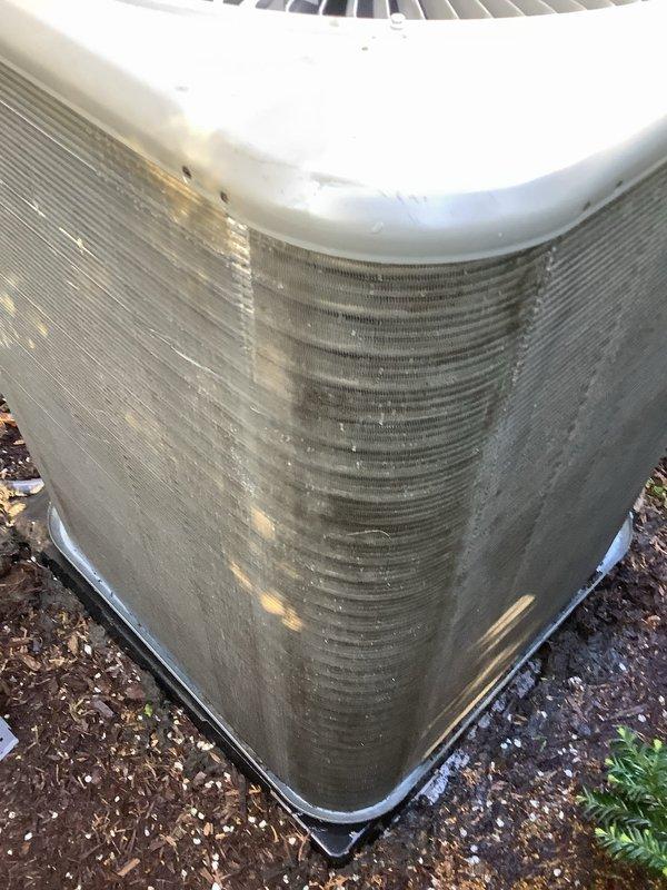 Completed routine Air Care Maintenance on outdoor heat pump unit. Inspected condenser coil which showed significant accumulation of dirt, dust, and debris with visible streaking and discoloration across aluminum fins. Performed system diagnostics using manifold gauges and digital instruments to verify refrigerant pressures and overall system performance.