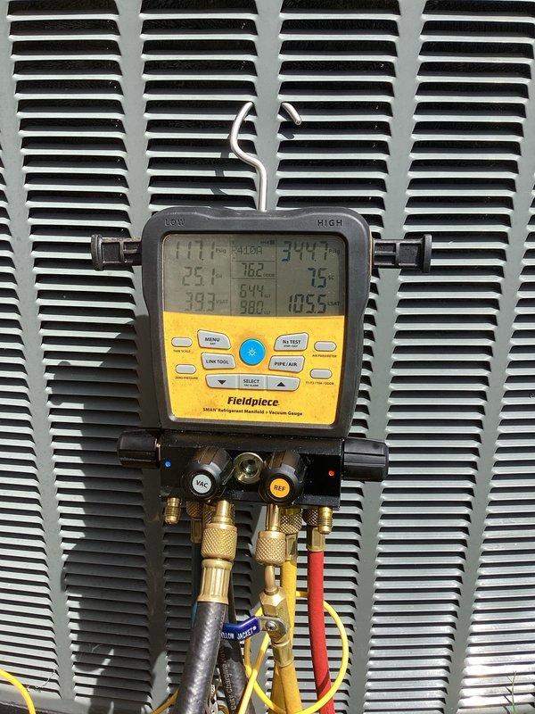 Completed annual cooling maintenance on rooftop zone unit. Performed system diagnostics using manifold gauges to verify refrigerant pressures and temperatures, with readings indicating normal operating parameters. Observed heavily soiled condenser coil with significant accumulation of dirt, dust, and debris restricting airflow. Opened outdoor unit access panel to inspect internal components, noting weathered copper refrigerant lines and clogged coil fins requiring future cleaning attention. System currently operational but would benefit from professional coil cleaning to restore optimal efficiency and heat transfer capability.