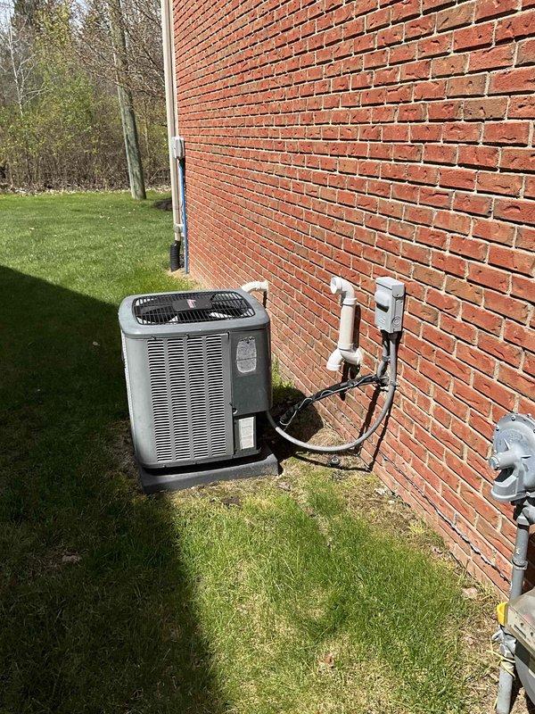 Provided comprehensive estimate for complete HVAC system replacement including natural gas furnace located in basement and outdoor air conditioning condensing unit. Current 10-year-old equipment operational but nearing end of service life. Evaluated existing installation including ductwork connections, PVC condensate drainage, electrical service, and outdoor unit placement on concrete pad with refrigerant lines and conduit routed along exterior brick wall.