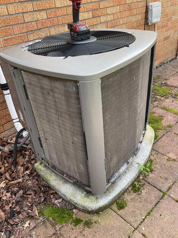 Completed annual cooling maintenance on residential condensing unit. Performed comprehensive inspection of outdoor unit including cleaning of condenser coils, checking refrigerant levels, testing electrical connections, and verifying proper fan motor operation. Unit found in good working condition with normal wear consistent with outdoor exposure. Concrete pad shows moss accumulation but remains structurally sound for equipment support.