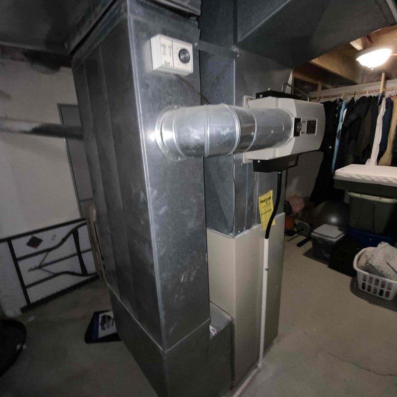 Conducted comprehensive assessment of existing HVAC system in residential single-family home where air conditioning unit was operating inconsistently. Both the air conditioning system and furnace were documented at 25 years of age, well beyond their typical service life expectancy. Evaluated current equipment condition, ductwork configuration, and existing infrastructure in basement utility area. Photographed existing gray metal furnace unit with control panel and connected ductwork, as well as water heater and associated mechanical systems to document current installation layout. Prepared full system replacement estimate for both heating and cooling equipment to address reliability concerns and provide modern, efficient HVAC solution.
