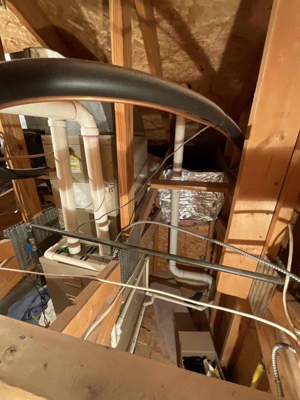 Provided estimate for replacement of two air conditioning units and one furnace in a residential property with equipment located in basement and attic spaces. Assessed existing HVAC systems including attic-mounted air handler with associated ductwork and PVC condensate drainage, noting one furnace was recently replaced while air conditioning units and secondary furnace require replacement due to age. Accessed attic equipment via ladder to evaluate installation conditions and existing duct configurations for proper sizing and equipment recommendations.