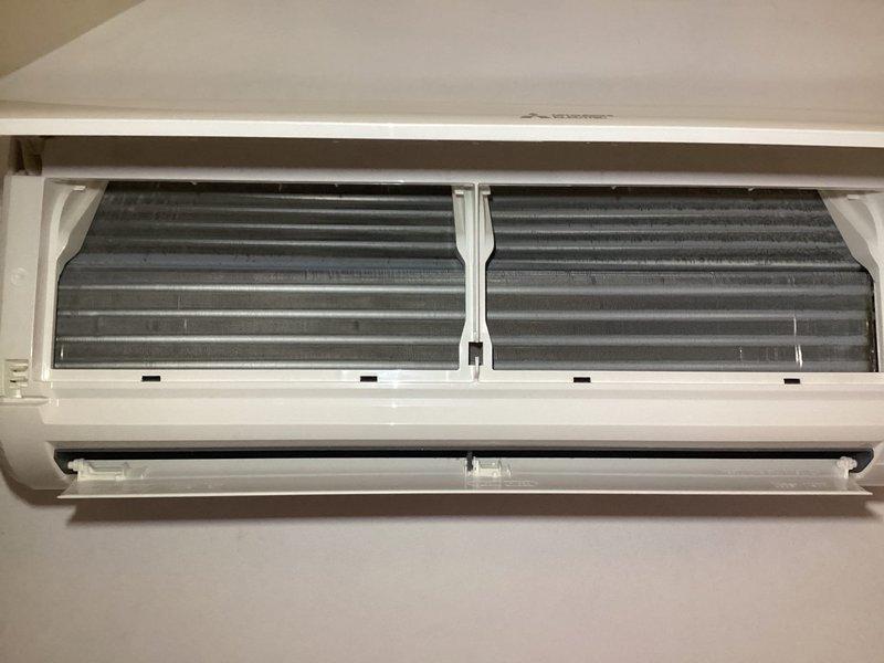 Responded to service call for 4-year-old mini split system reporting sweet smell from indoor unit after outdoor condenser was knocked over during windstorm. Upon inspection, unit was operational and maintaining cooling capacity with no visible refrigerant leaks at exterior condenser location. Opened indoor evaporator unit and found moderate dust and dirt accumulation on coil fins, with darker patches indicating restricted airflow contributing to odor issue. Documented internal coil condition with photos showing contaminated evaporator surfaces. System remained functional throughout inspection with no immediate safety concerns identified.