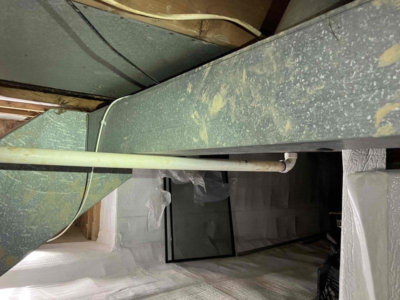 Provided estimate for new air conditioning system installation at residential property. Assessed crawl space location containing existing air handler unit with associated ductwork and PVC condensate drainage system. Evaluated structural conditions, vapor barrier installation, and available space for potential AC condenser placement outside the home to complete the cooling system configuration.