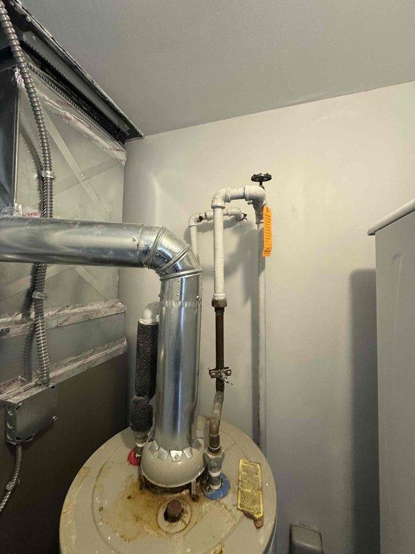 Completed estimate for standard water heater replacement in laundry room utility space. Assessed existing A.O. Smith water heater installation with natural draft venting, confirmed current unit operational, documented piping connections including PVC and copper lines, pressure relief valve, and proximity to HVAC air handler equipment. Provided quote for new standard tank water heater installation with consideration for tight clearance requirements and existing plumbing configuration.
