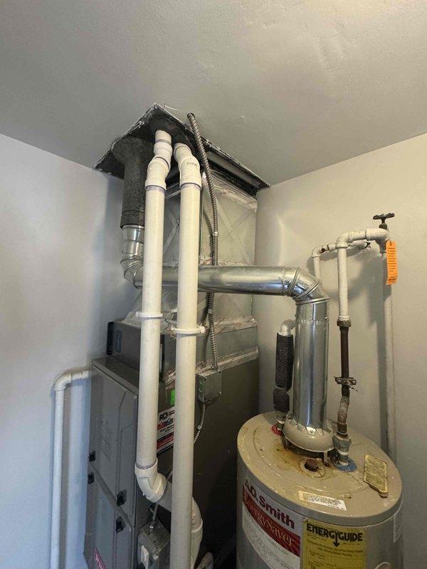 Completed estimate for standard water heater replacement in laundry room utility space. Assessed existing A.O. Smith water heater installation with natural draft venting, confirmed current unit operational, documented piping connections including PVC and copper lines, pressure relief valve, and proximity to HVAC air handler equipment. Provided quote for new standard tank water heater installation with consideration for tight clearance requirements and existing plumbing configuration.