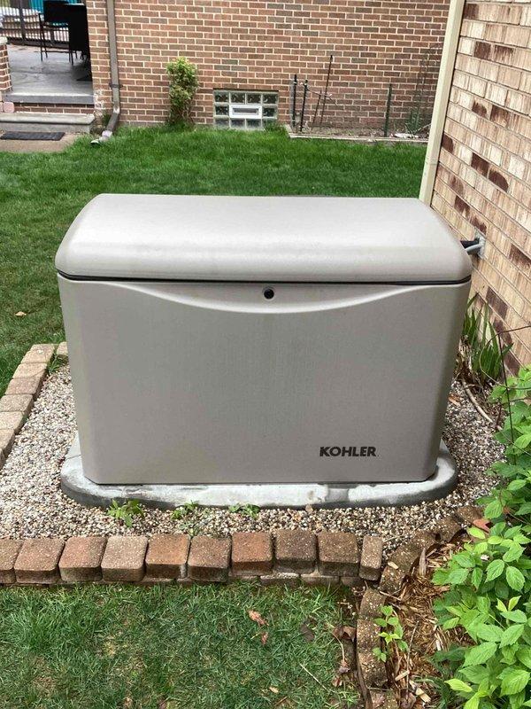 Performed electrical maintenance on a Kohler 14kW standby generator. Delivered and supplied bring kit components for Code compliance. Unit control panel displaying proper serial number and updated firmware version 7879, with all operational modes (OFF/AUTO/RUN) functioning correctly and indicator lights operational.