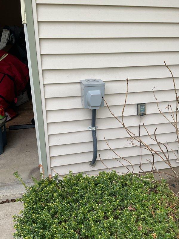 Installed a dedicated EV charger outlet on the exterior of the residence, running weatherproof conduit from a new circuit breaker in the main electrical panel to a gray NEMA outlet box mounted on the home's siding. Added and labeled a new breaker in the panel to support the charging station load, with proper circuit directory documentation noting "EV Plug" for future reference.