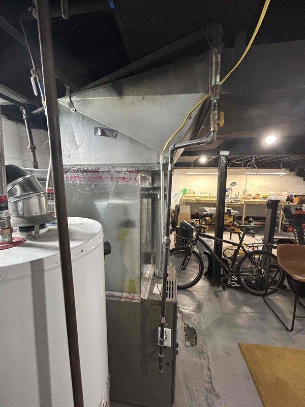 Conducted on-site evaluation for air conditioning system installation at property with existing forced air furnace. Assessed basement mechanical room containing Evcon furnace unit and current ductwork infrastructure to determine compatibility and requirements for AC addition. Documented existing HVAC equipment configuration, available electrical capacity, and ductwork layout to prepare comprehensive estimate for split system air conditioning installation to work in conjunction with existing forced air heating system.