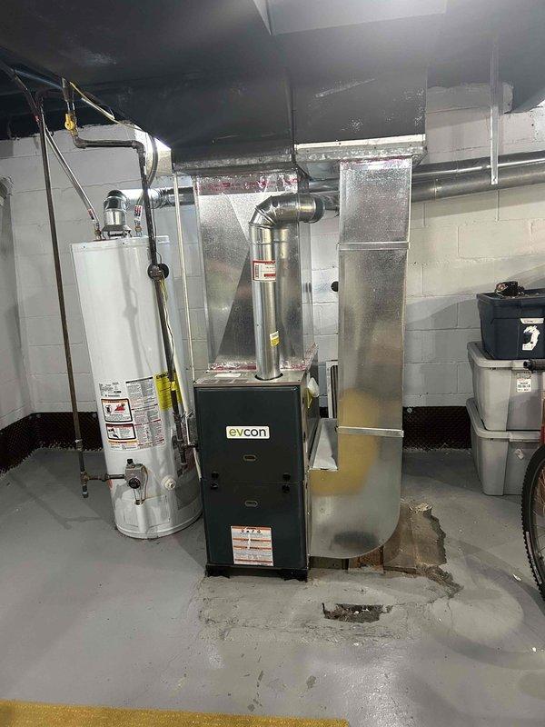 Conducted on-site evaluation for air conditioning system installation at property with existing forced air furnace. Assessed basement mechanical room containing Evcon furnace unit and current ductwork infrastructure to determine compatibility and requirements for AC addition. Documented existing HVAC equipment configuration, available electrical capacity, and ductwork layout to prepare comprehensive estimate for split system air conditioning installation to work in conjunction with existing forced air heating system.