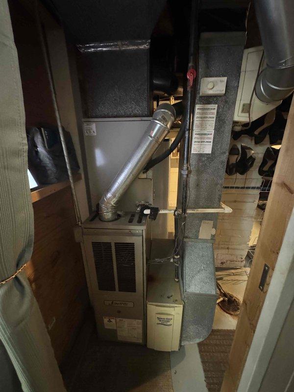 Conducted comprehensive on-site assessment for complete HVAC system replacement in single-family residence under 800 square feet. Evaluated existing furnace and air conditioning equipment located in confined basement mechanical space, documenting current system configuration including ductwork routing, clearance constraints, and utility connections. Photographed installation area showing beige furnace unit with vertical exhaust venting, adjacent water heater with corroded piping, and silver metallic ductwork running through structural beams with limited clearance. Assessed mechanical room layout including plywood subflooring, electrical outlets, support columns, and tight workspace conditions that will impact equipment removal and new system installation. Prepared detailed estimate for expedited full system replacement including new furnace and air conditioning unit sized appropriately for square footage, accounting for existing ductwork integration and space limitations in mechanical 