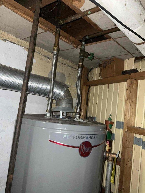 Provided comprehensive estimate for water heater replacement options, including both standard tank and tankless configurations for new installation. Assessed existing non-functional Rheem Performance water heater showing significant water damage and deterioration at base, with visible staining on floor tiles indicating previous leakage issues. Documented current plumbing configuration including copper supply lines, shut-off valves, and venting requirements in unfinished basement utility space to determine optimal replacement solution and installation specifications.