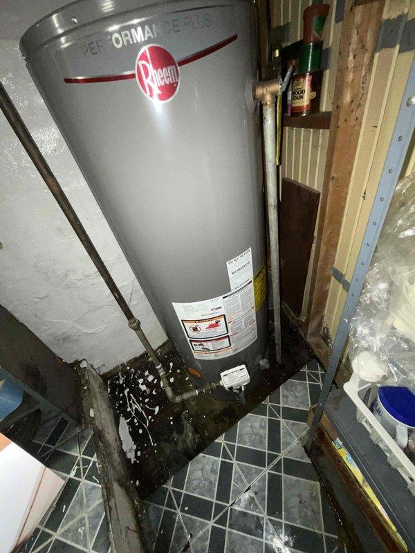 Provided comprehensive estimate for water heater replacement options, including both standard tank and tankless configurations for new installation. Assessed existing non-functional Rheem Performance water heater showing significant water damage and deterioration at base, with visible staining on floor tiles indicating previous leakage issues. Documented current plumbing configuration including copper supply lines, shut-off valves, and venting requirements in unfinished basement utility space to determine optimal replacement solution and installation specifications.
