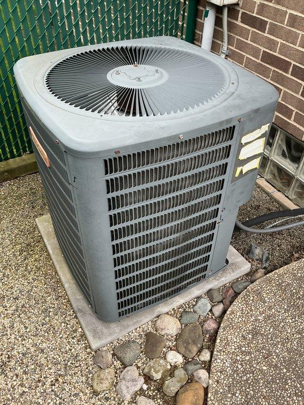 Performed routine air conditioning maintenance on residential condenser unit. Conducted refrigerant pressure analysis using manifold gauges, recording low-side pressure at 60.8 PSIG with 15°F superheat and high-side pressure at 149.3 PSIG, confirming system operating within normal parameters. Inspected condenser unit exterior condition, verified proper airflow through louvered panels, and documented equipment status with unit positioned on concrete pad with adequate clearance.