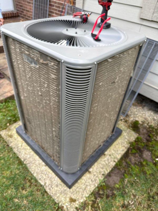 Performed annual preventive maintenance on residential split system air conditioning unit. Inspected condenser unit exterior panels, verified proper airflow through louvered sides, and checked fan grille assembly for secure mounting and operational integrity. Unit found in good working condition with all components functioning as designed.