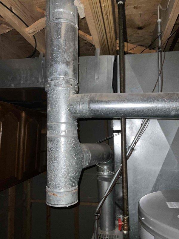 Completed commercial HVAC system installation including outdoor condenser unit and indoor ductwork components. Installed new condenser unit on concrete pad with proper electrical disconnect and line set connections. Configured basement ductwork system with metallic supply lines and secured all connections with appropriate clamps and fasteners. System tested and operational upon completion, with all components functioning per manufacturer specifications.
