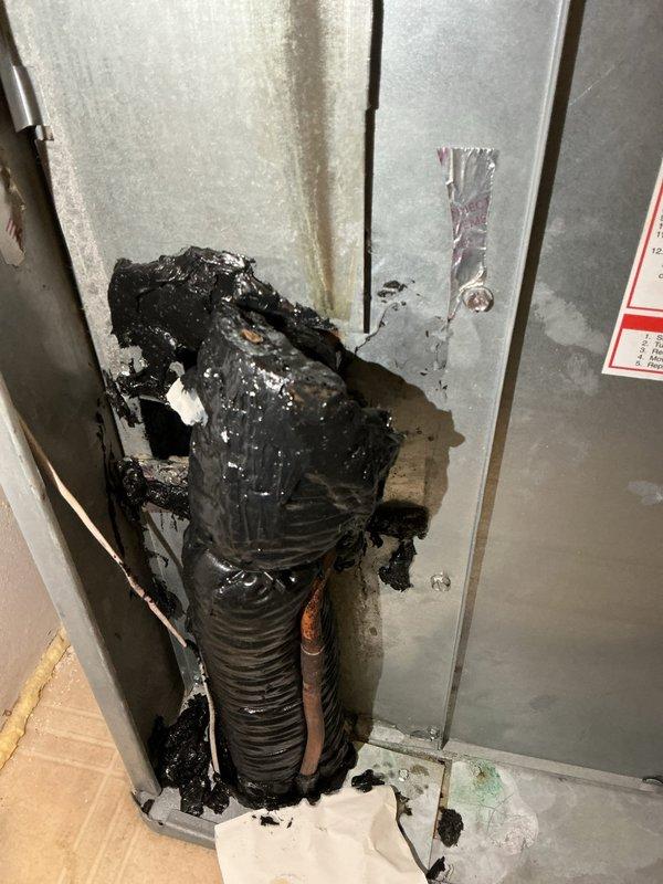 Completed annual preventive maintenance on Evcon rooftop air conditioning system. During inspection, discovered severe heat damage to flexible duct connection with melted and deteriorated corrugated hose material at equipment housing penetration point. Documented damaged components including compromised metal panel with discoloration and structural breach. Verified outdoor condensing unit operational status and inspected all accessible system components per ACM protocol.