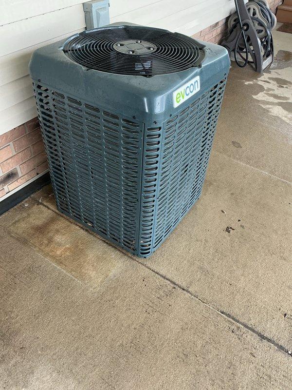 Completed annual preventive maintenance on Evcon rooftop air conditioning system. During inspection, discovered severe heat damage to flexible duct connection with melted and deteriorated corrugated hose material at equipment housing penetration point. Documented damaged components including compromised metal panel with discoloration and structural breach. Verified outdoor condensing unit operational status and inspected all accessible system components per ACM protocol.