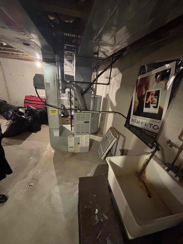 Completed comprehensive site evaluation and estimate preparation for replacement of 30-year-old original 1996 air conditioning system serving 1500 square foot owner-occupied residential condo unit. Assessed existing HVAC equipment configuration in basement mechanical room, including furnace unit, ductwork routing, available installation space, and electrical service compatibility. Documented current system layout with photographic evidence showing beige furnace with black flexible ductwork, metal supply/return duct runs along ceiling joists, water heater positioning, utility sink clearances, and overall equipment accessibility for replacement work. Evaluated structural considerations for new AC unit installation including adequate clearances, proper drainage routing, refrigerant line pathways through existing infrastructure, and condensate management. Confirmed electrical panel capacity and wiring requirements for modern high-efficiency equipment. Measured ductwork dimensions and asses