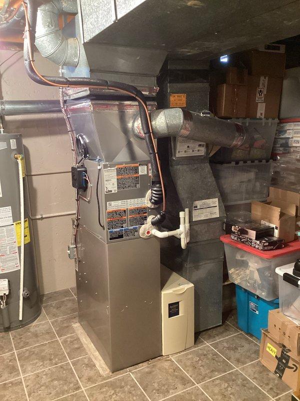 Completed installation of 2-ton air conditioning system with evaporator coil in basement mechanical room. Unit positioned with rear discharge configuration, copper refrigerant lines properly connected and insulated, system reconnected to existing electrical service. System tested and verified operational with proper refrigerant pressures and airflow measurements confirmed using diagnostic equipment.