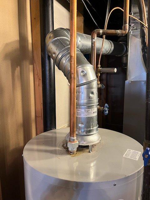 Responded to service call for 15-year-old tanked water heater experiencing operational failure with 5-flash error code and shutting down after approximately 10 minutes of runtime. Upon arrival, performed diagnostic inspection of the unit and associated venting system. Evaluated gas supply, burner assembly, thermocouple, and control board functionality. Inspected flue venting configuration and clearances. Assessed electrical connections and grounding. Based on age of equipment and diagnostic findings, provided customer with repair versus replacement options and recommendations. No parts were installed and no repairs were performed at this time. Documented existing installation with photos showing water heater, venting system, and surrounding mechanical equipment for reference.