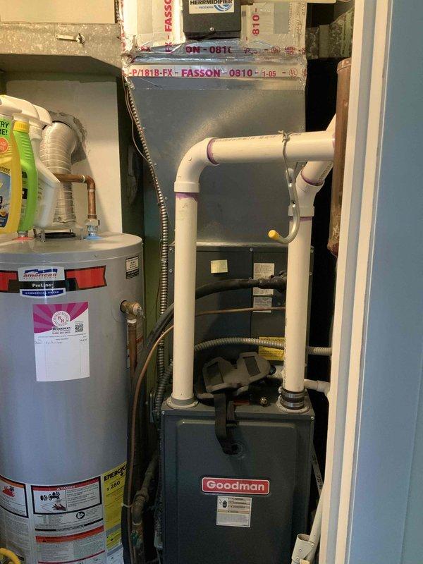 Provided replacement estimate for non-operational air conditioning system over 30 years old located in utility closet alongside existing Goodman furnace and water heater. Assessed current equipment configuration including ductwork system with metal supply plenum and flexible ducting routed through confined space, evaluated existing PVC condensate drain lines and gas connections for compatibility with replacement unit specifications.