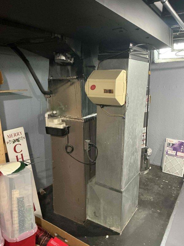 Completed full system estimate for replacement of 15-year-old furnace and air conditioning system in residential basement mechanical room. Assessed existing equipment condition, including furnace with mounted humidifier component and air handler unit with associated ductwork. Customer requested immediate replacement quote for outdated HVAC system. Documented current equipment configuration and specifications through photographic documentation of furnace, air handler, ductwork, and electrical connections to provide accurate replacement system recommendations.