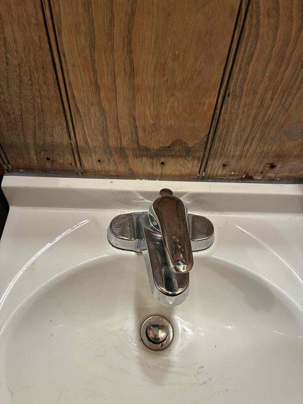 Responded to water leak complaint originating from basement pipe directly below bathroom sink. Upon arrival, accessed property per customer accessibility needs. Inspected bathroom sink installation featuring chrome single-handle faucet on white porcelain basin with wall-mounted configuration. Traced leak source to supply line connection beneath fixture in basement area. Water shutoff had not been activated prior to arrival. Performed diagnostic assessment of plumbing connections, identified dripping pipe, and completed necessary repairs to eliminate active water leak and restore system integrity.