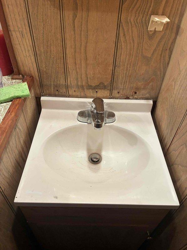 Responded to water leak complaint originating from basement pipe directly below bathroom sink. Upon arrival, accessed property per customer accessibility needs. Inspected bathroom sink installation featuring chrome single-handle faucet on white porcelain basin with wall-mounted configuration. Traced leak source to supply line connection beneath fixture in basement area. Water shutoff had not been activated prior to arrival. Performed diagnostic assessment of plumbing connections, identified dripping pipe, and completed necessary repairs to eliminate active water leak and restore system integrity.