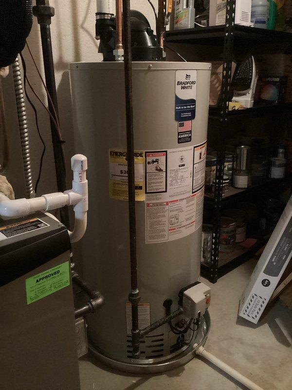 Successfully installed a 50-gallon Bradford White power vent water heater in the basement utility area. The installation included proper copper piping connections, PVC venting, safety valves, and placement on a metal drip pan per code requirements. All mechanical and electrical connections were completed, and the unit was tested for proper operation.