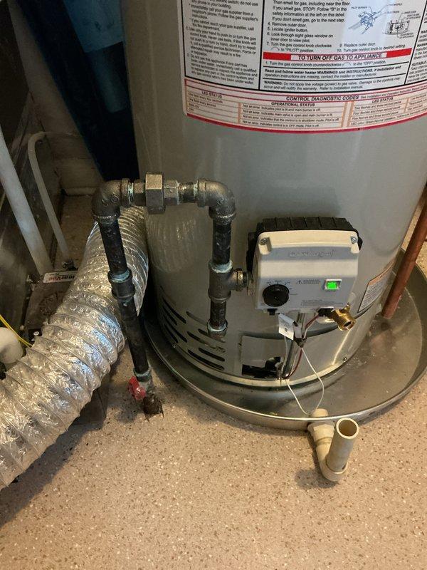 Installed a 40-gallon Bradford White residential water heater with B-vent exhaust system in utility room. Connected supply and discharge plumbing lines using brass fittings and flexible connectors, installed drain pan beneath unit, and established proper venting through existing ductwork. All mechanical connections were completed per code requirements, with permits obtained for mechanical and reconnection work.