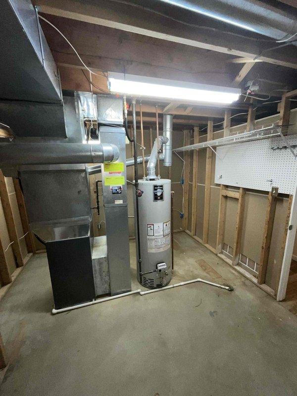 Conducted on-site evaluation for air conditioning system replacement estimate. Inspected existing mechanical equipment located in unfinished basement area, including current furnace and water heater configuration, ductwork infrastructure, and available space for new AC installation. Documented existing conditions through photographs of indoor mechanical room showing exposed framing, concrete flooring, and overhead duct routing, as well as exterior areas where outdoor condensing unit would be positioned. Assessed electrical service capacity, drainage requirements, refrigerant line routing options, and integration points with existing HVAC infrastructure to provide comprehensive replacement system recommendations.