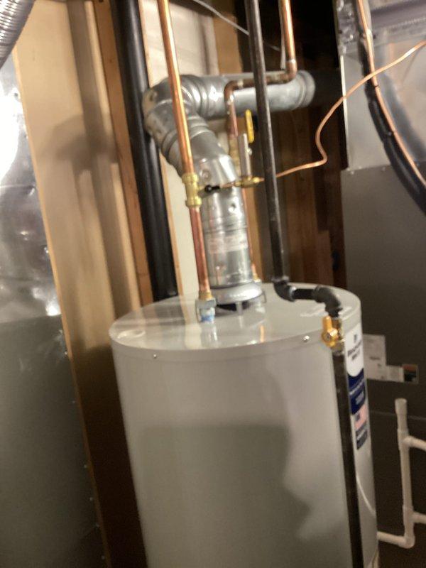 Completed installation of a 50-gallon tanked water heater in basement mechanical room. Removed existing unit and installed new water heater with proper venting configuration, connected copper supply and discharge piping with appropriate fittings and valves, and installed temperature and pressure relief valve with discharge piping per code requirements. Verified all plumbing connections for leaks, tested unit operation, and ensured proper clearances from adjacent HVAC equipment. Requested mechanical and plumbing permits for water heater installation and reconnection work.