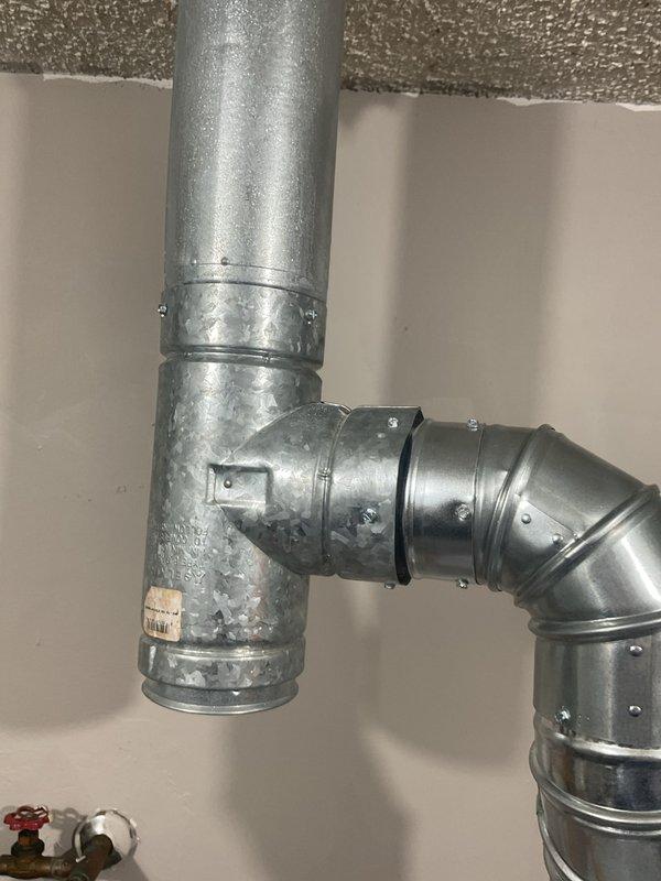 Completed warranty service on recently installed HVAC system by removing tape from water heater exhaust vent and straightening the vent pipe connection at the tank. The original installation included a 90,000 BTU furnace, 4-ton air conditioning unit with rear-yard condenser placement, and 150-amp electrical panel upgrade. Corrected the water heater venting configuration to ensure proper exhaust flow and code compliance. Verified all galvanized ductwork connections are secure and properly aligned, with water heater vent pipe now properly positioned and free of obstructions. All mechanical, electrical, and HVAC permits were obtained for the complete system installation.