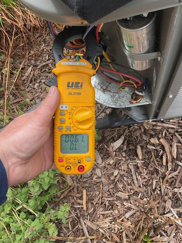 Completed annual cooling maintenance on residential HVAC system. Performed comprehensive inspection of outdoor condensing unit, measuring electrical parameters including voltage and amperage draw using digital multimeter. Verified proper compressor operation and capacitor function with all readings within manufacturer specifications at 0.183 reading observed. Inspected indoor air handler unit, checking blower motor assembly and electrical connections. All wiring connections secure with no signs of overheating or deterioration noted. System operating efficiently with no deficiencies found during inspection.
