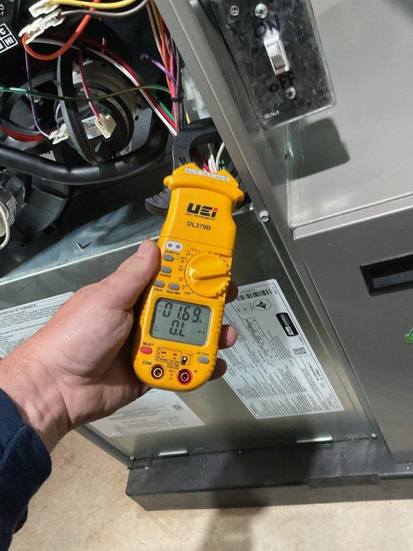 Completed annual cooling maintenance on residential HVAC system. Performed comprehensive inspection of outdoor condensing unit, measuring electrical parameters including voltage and amperage draw using digital multimeter. Verified proper compressor operation and capacitor function with all readings within manufacturer specifications at 0.183 reading observed. Inspected indoor air handler unit, checking blower motor assembly and electrical connections. All wiring connections secure with no signs of overheating or deterioration noted. System operating efficiently with no deficiencies found during inspection.