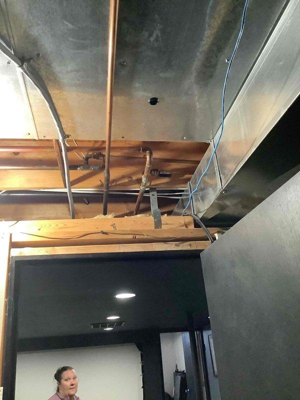 Conducted comprehensive site evaluation for new whole home generator installation at residential property. Assessed existing electrical service panel location in basement utility area and evaluated overhead infrastructure including exposed ceiling joists, copper plumbing lines, and HVAC ductwork to determine optimal routing for generator transfer switch wiring and gas line connections. Documented electrical panel configuration and available overhead pathways to develop installation plan for automatic transfer switch integration with main electrical service.