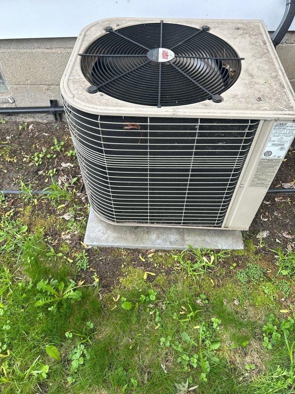 Completed annual cooling maintenance on residential outdoor condensing unit. Performed comprehensive inspection of condenser cabinet, coil, and fan assembly. Verified proper operation of condenser fan motor and checked fan blade condition. Inspected refrigerant lines for signs of wear or damage. Examined unit mounting and concrete pad for stability. Cleared debris and vegetation from around unit perimeter to ensure adequate airflow. Documented equipment condition with photographs showing weathered cabinet exterior with normal operational wear. Unit operating within normal parameters upon completion of maintenance visit.